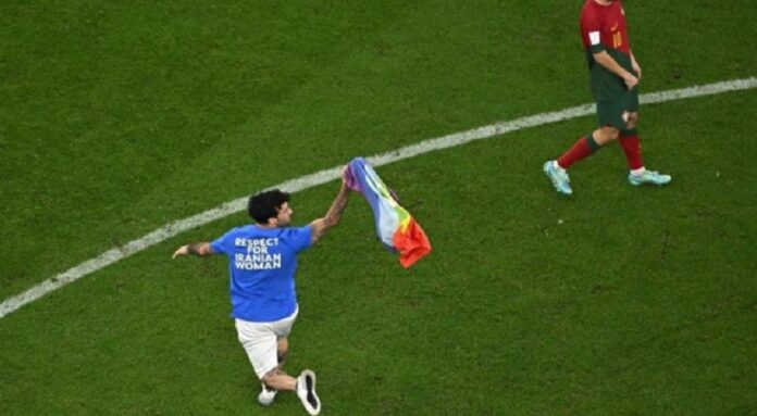 torcedor invade campo com bandeira lgbtqia+ durante jogo da copa do catar